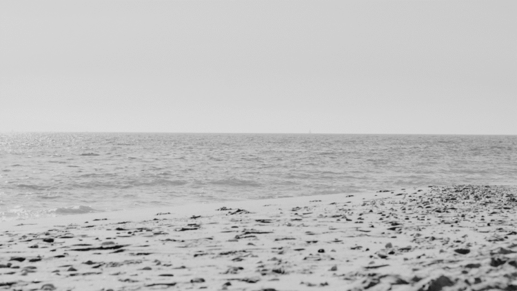 foto de uma praia aleatória vazia com a areia e o mar ao fundo